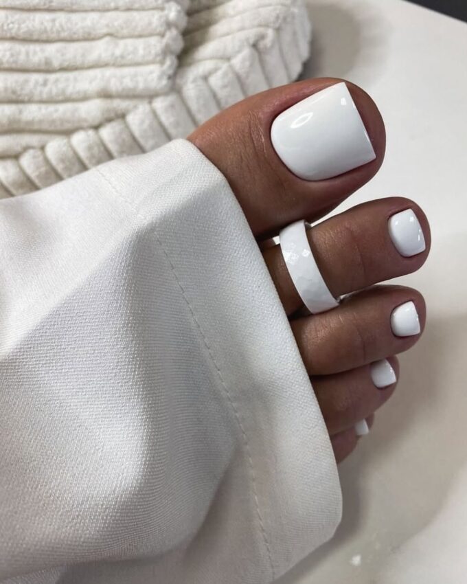 Pédicure blanche brillante dans un style minimaliste