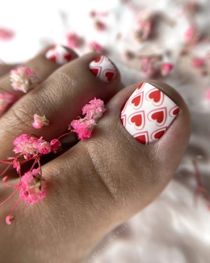 Pédicure avec des cœurs rouges sur fond blanc entouré de fleurs roses